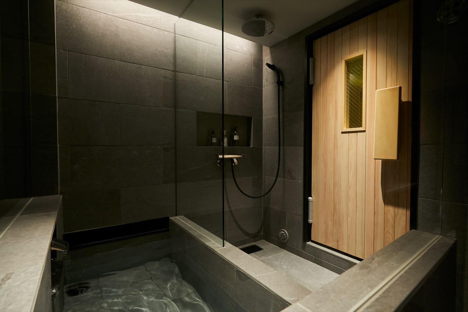 水風呂とレインシャワー、右奥にサウナ室の扉